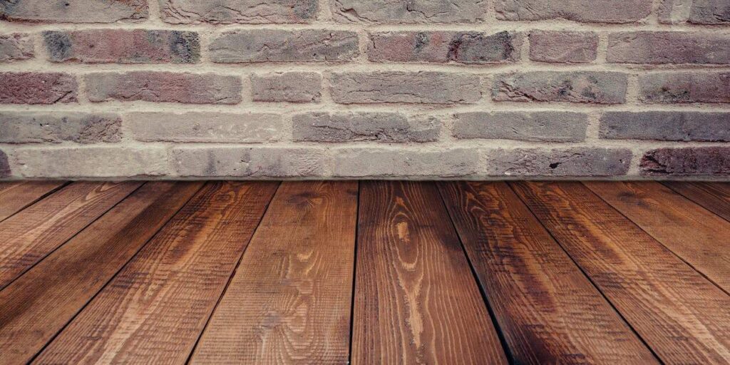 Wooden Floor with Brick Wall Background