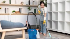 Young woman mopping floors while maintaining a clean and organized home environment.