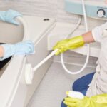 professional cleaners cleaning bathtub in bathroom