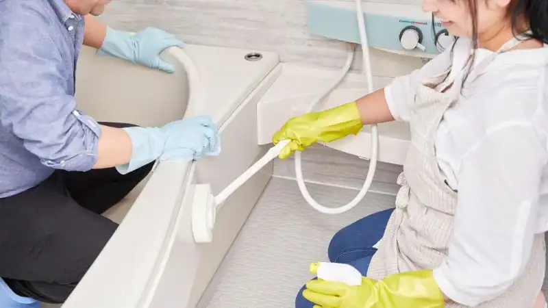 professional cleaners cleaning bathtub in bathroom