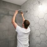 a person inspecting a shower head in neat and clean bathroom