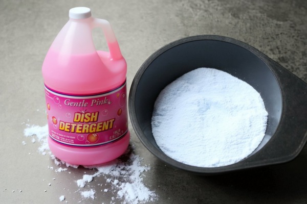 Pink dish detergent container beside bowl of white bleaching powder.