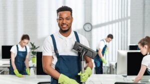 A Male cleaner and his Cleaning Staff