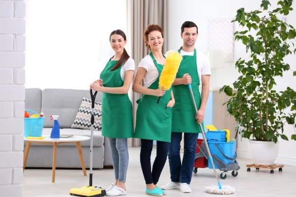 Team of professional cleaners with cleaning tools and equipment